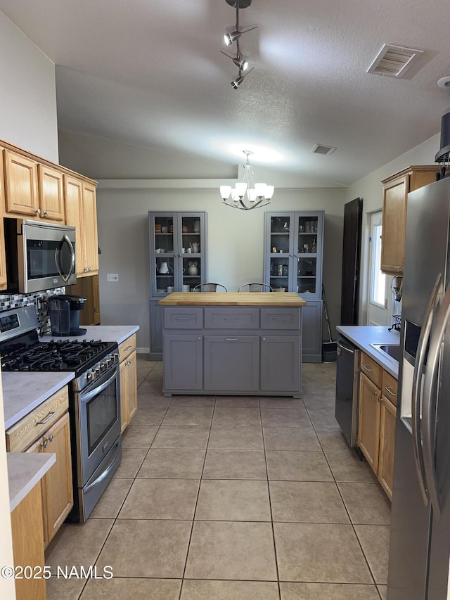 kitchen featuring light tile patterned flooring, visible vents, appliances with stainless steel finishes, and a chandelier