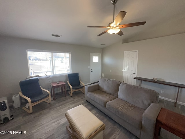 living room with lofted ceiling, baseboards, visible vents, a ceiling fan, and wood finished floors