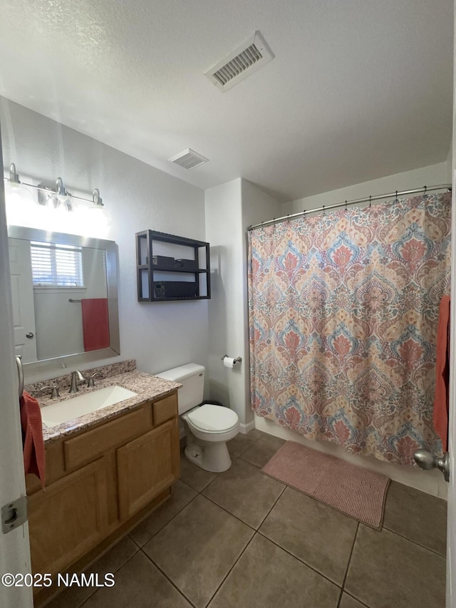 bathroom featuring a textured ceiling, visible vents, toilet, vanity, and tile patterned flooring