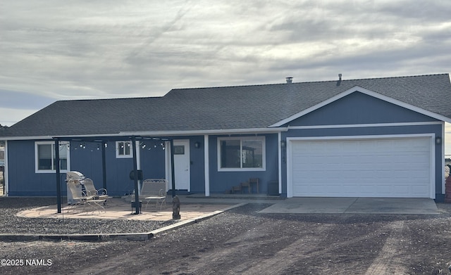 ranch-style house featuring driveway, a garage, and a shingled roof