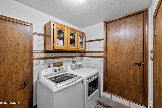 2201 N Rio De Flag Dr, Flagstaff, AZ 86004 - washroom with washer and dryer, cabinet space, a textured ceiling, and tile walls