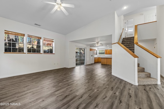 unfurnished living room featuring dark wood-style floors, stairway, visible vents, and a ceiling fan