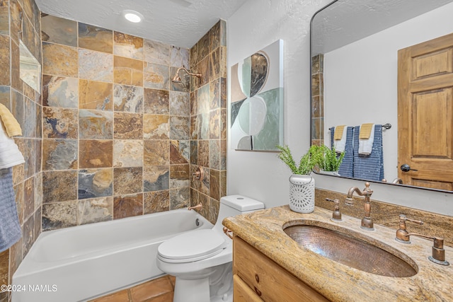 full bathroom with a textured ceiling, toilet, vanity, and tiled shower / bath