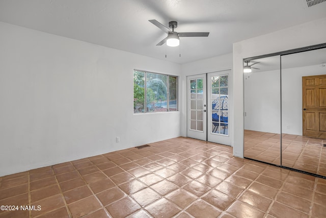 unfurnished bedroom featuring ceiling fan, light tile patterned floors, a closet, and french doors