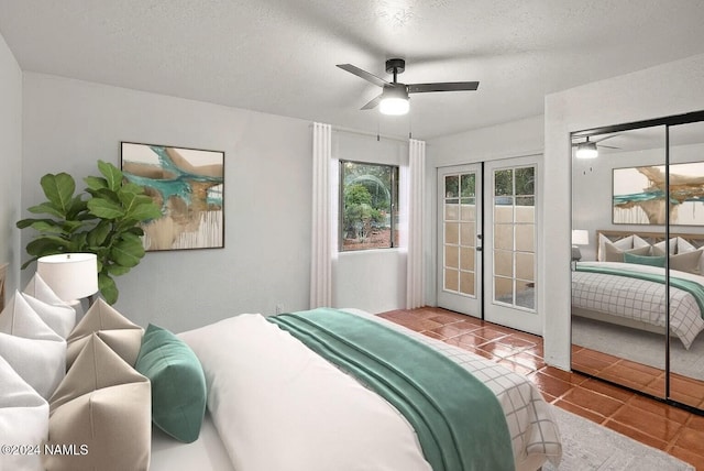 bedroom with ceiling fan, french doors, tile patterned floors, and a textured ceiling