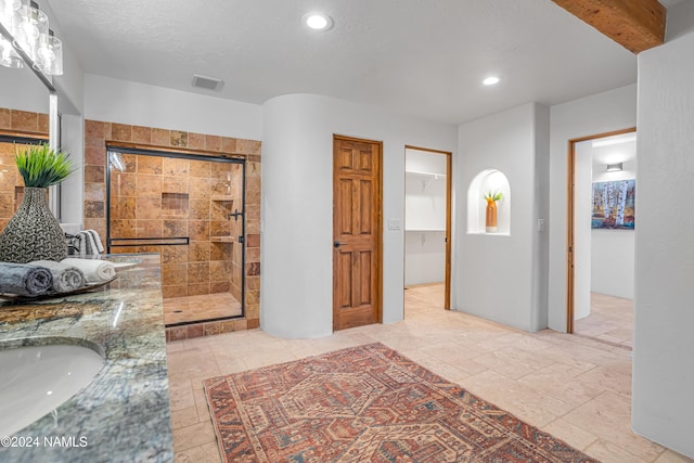 bathroom featuring vanity and tiled shower