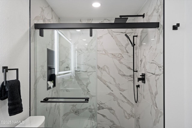 full bathroom with toilet and a marble finish shower