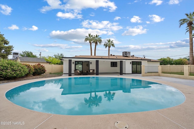 view of pool featuring fence, a patio area, and central AC unit