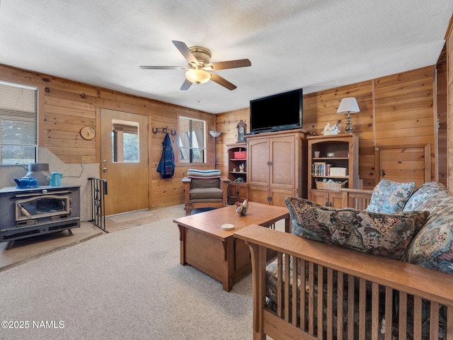 7284 N Buck Ridge Rd, Williams, AZ 86046 - living area with wooden walls, ceiling fan, a wood stove, and light carpet