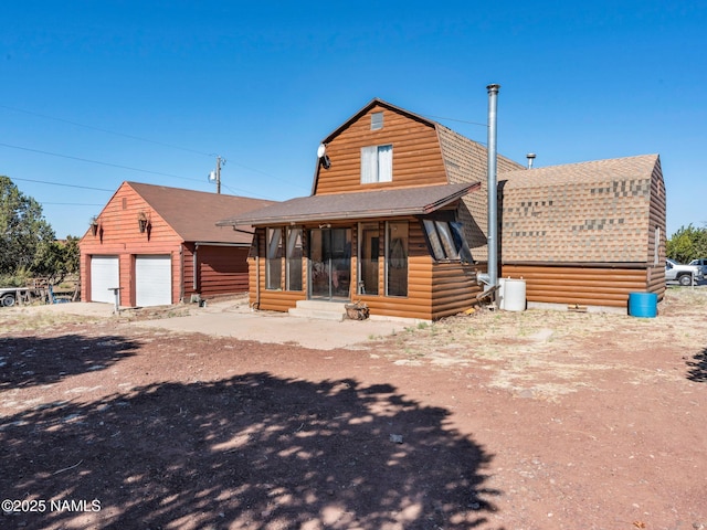 7284 N Buck Ridge Rd, Williams, AZ 86046 - view of front of home with roof with shingles, a sunroom, a garage, an outbuilding, and a gambrel roof