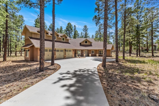 1090 E Hattie Greene, Flagstaff, AZ 86001 - view of front of house featuring driveway, a garage, a shingled roof, and board and batten siding