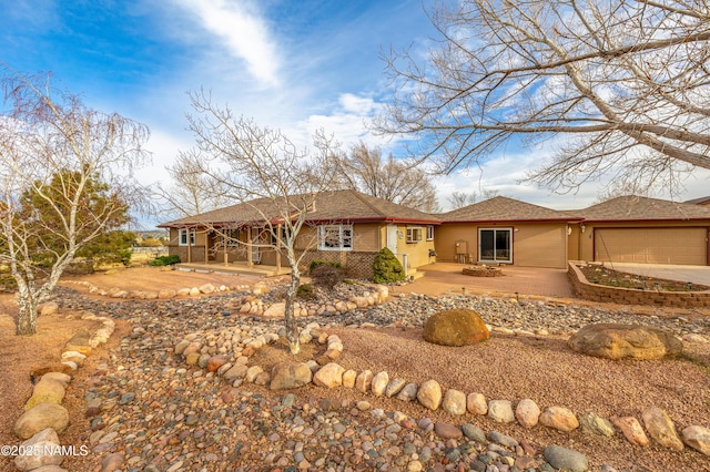 rear view of property with an attached garage, driveway, and brick siding