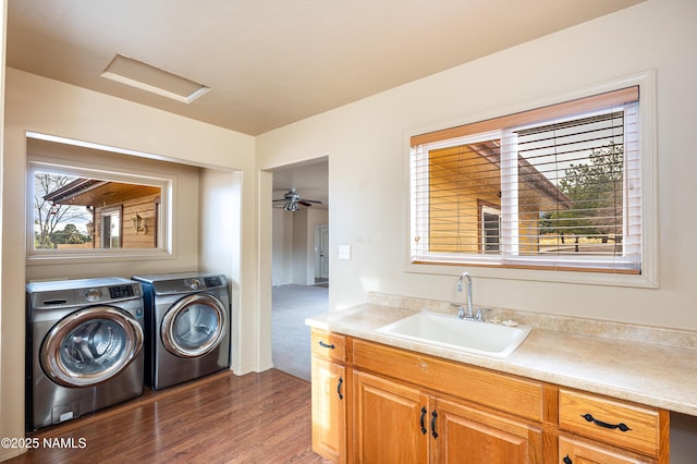 laundry area with dark wood finished floors, separate washer and dryer, a sink, and a wealth of natural light