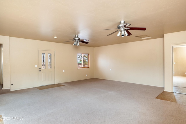 interior space featuring ceiling fan, carpet flooring, and attic access