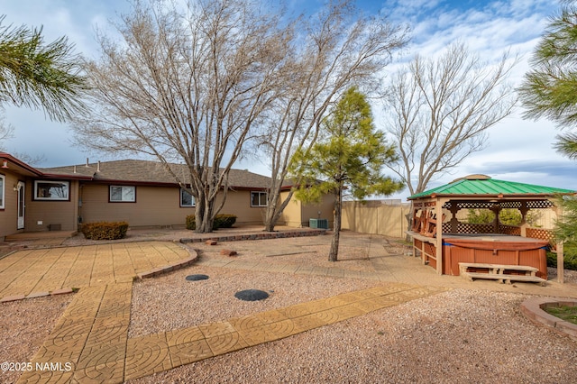 view of yard featuring a gazebo, a patio, fence, and a hot tub