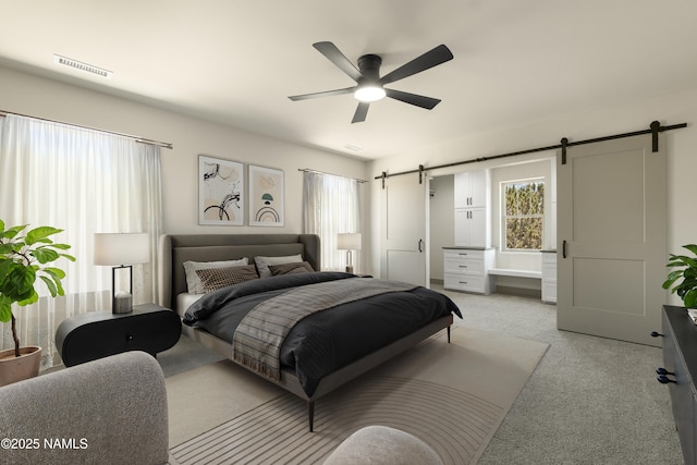 bedroom with light carpet, ceiling fan, and a barn door