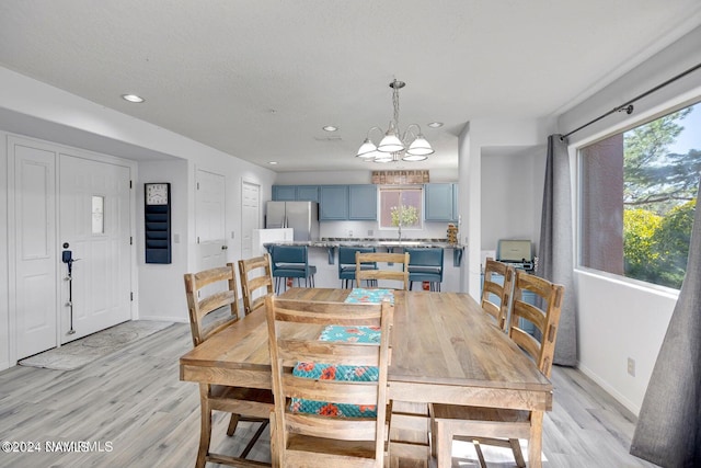 dining room featuring light wood-type flooring and a chandelier