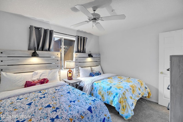 bedroom with ceiling fan, carpet, and a textured ceiling