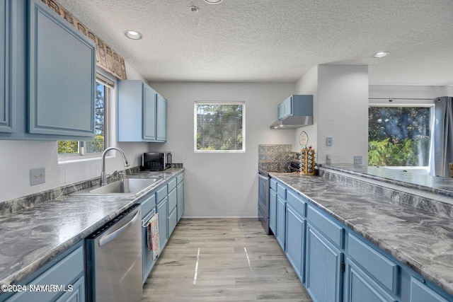 kitchen featuring sink, a textured ceiling, appliances with stainless steel finishes, and a healthy amount of sunlight