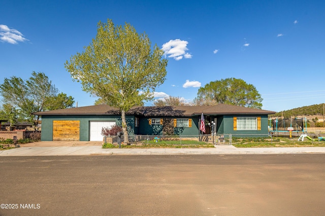 502 N Humbolt St, Williams, AZ 86046 - single story home with a fenced front yard, a garage, a trampoline, and concrete driveway