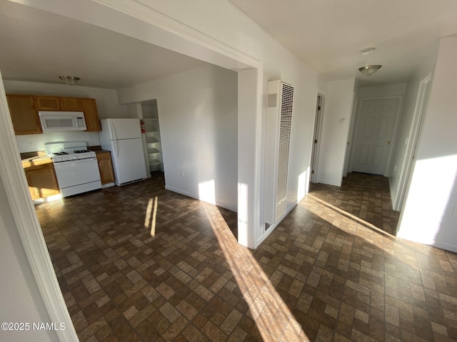 corridor with a heating unit and baseboards