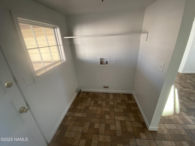 laundry area with brick floor, washer hookup, laundry area, and baseboards