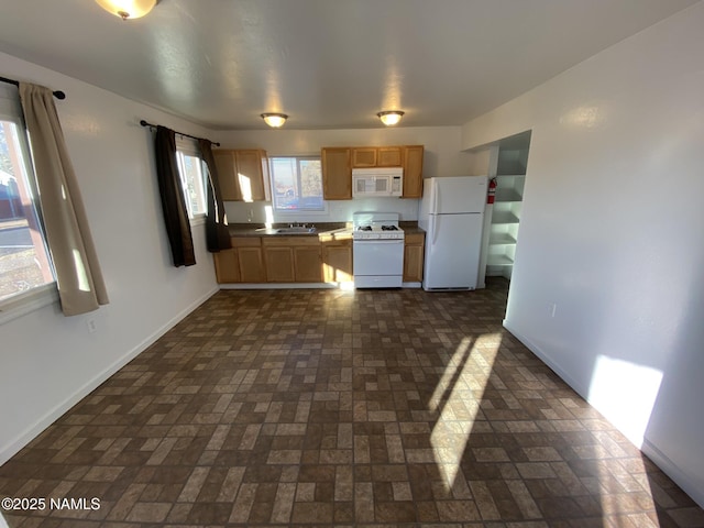 kitchen with white appliances, baseboards, brick floor, and a sink