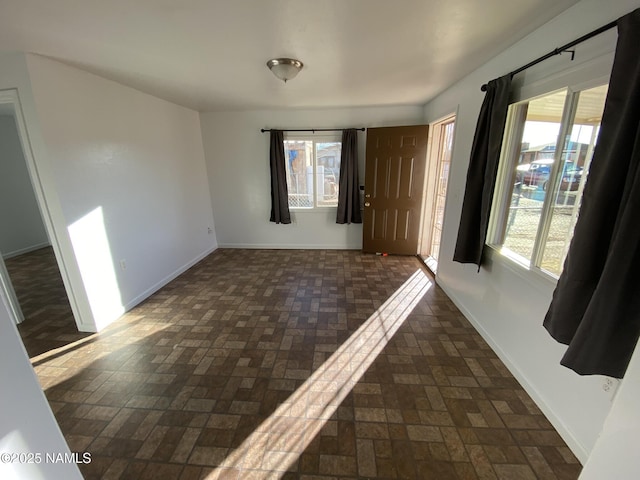 foyer entrance with brick floor and baseboards