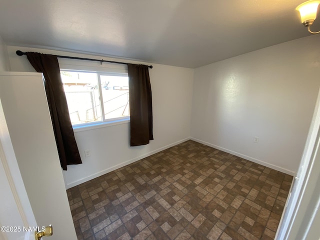 empty room with brick floor and baseboards