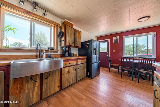 kitchen with sink, light wood-type flooring, and refrigerator with ice dispenser