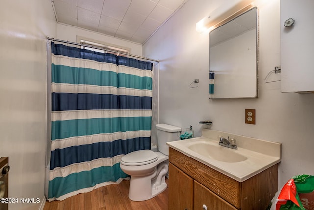 bathroom featuring hardwood / wood-style flooring, curtained shower, toilet, and vanity