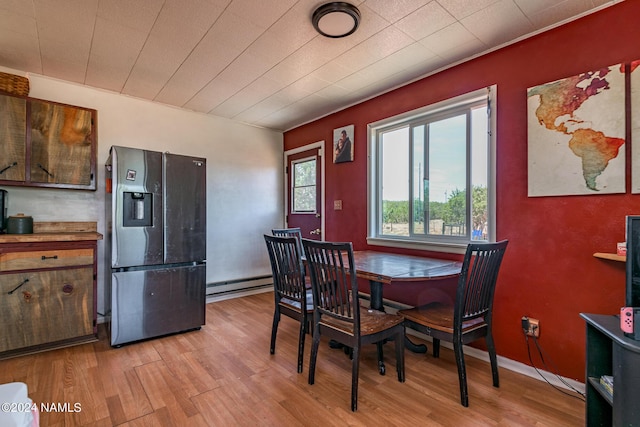 dining space featuring light hardwood / wood-style flooring and a baseboard heating unit