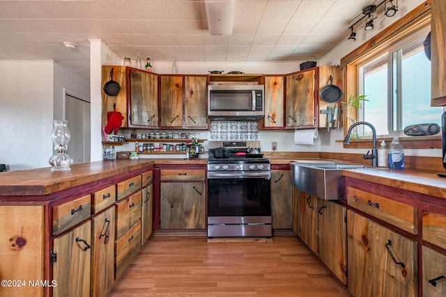 kitchen featuring light hardwood / wood-style floors, sink, backsplash, and stainless steel appliances