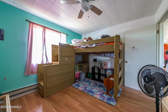 bedroom featuring a baseboard radiator, light wood-type flooring, and ceiling fan