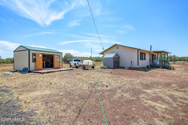 back of property with a garage and a storage unit