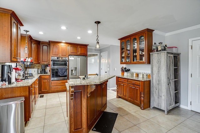 kitchen featuring decorative light fixtures, light tile patterned floors, an island with sink, stainless steel appliances, and light stone counters