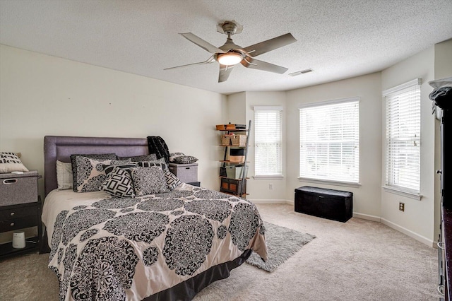 carpeted bedroom with multiple windows, a textured ceiling, and ceiling fan