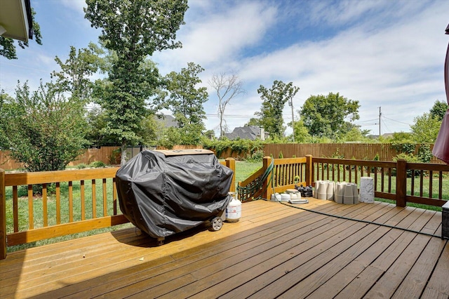 wooden terrace with a yard and area for grilling