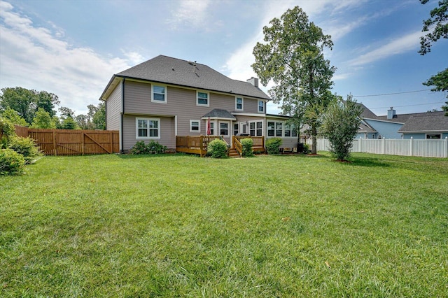 back of property featuring a yard and a deck