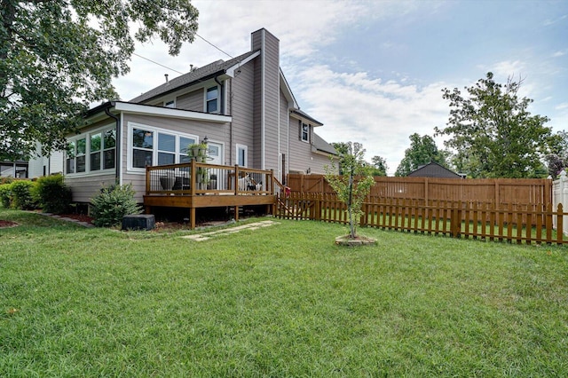 rear view of house with a yard and a deck