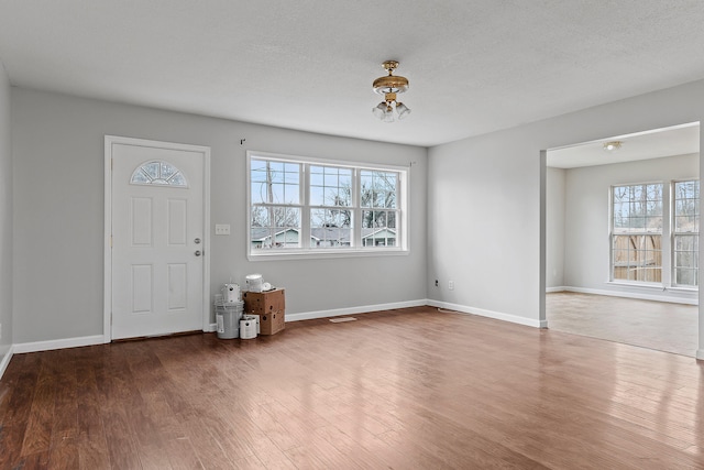 foyer featuring hardwood / wood-style floors, plenty of natural light, and a textured ceiling