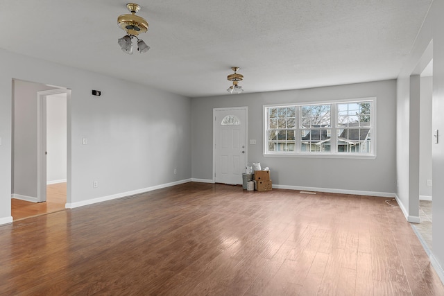 spare room featuring hardwood / wood-style floors and a textured ceiling