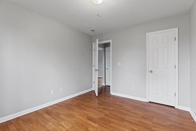 unfurnished bedroom with a textured ceiling and light hardwood / wood-style floors