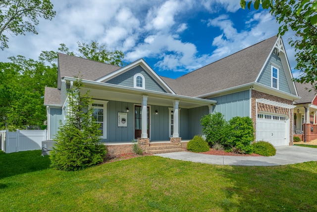 view of front of property featuring a garage, a porch, and a front yard