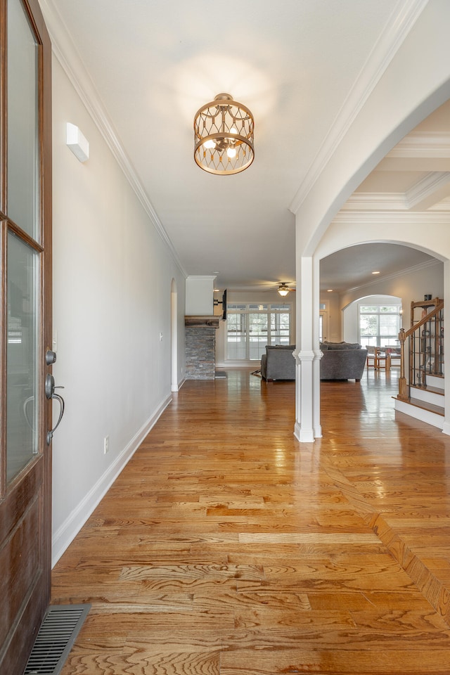 foyer with ornamental molding, wood-type flooring, and decorative columns