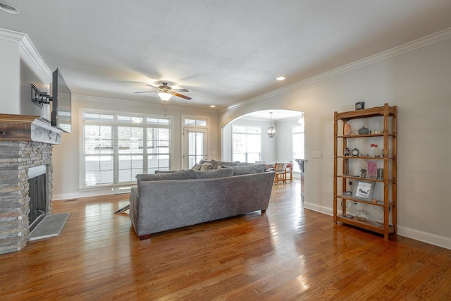 8337 Glenshire Ln, Chattanooga, TN 37421 - living room with ornamental molding, ceiling fan with notable chandelier, arched walkways, light wood-style flooring, and a fireplace