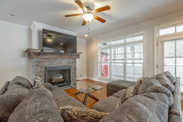 living room with a stone fireplace, plenty of natural light, ceiling fan, and hardwood / wood-style floors