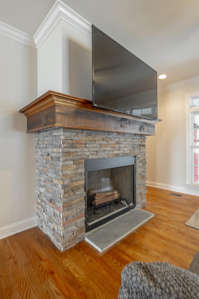 interior details with ornamental molding, hardwood / wood-style floors, and a fireplace