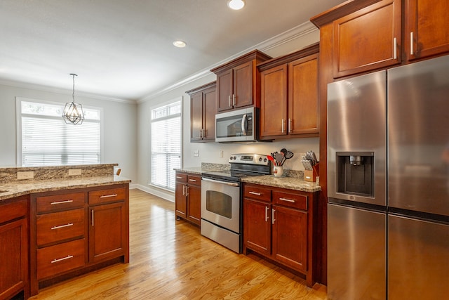 kitchen with ornamental molding, a healthy amount of sunlight, light wood-type flooring, and appliances with stainless steel finishes