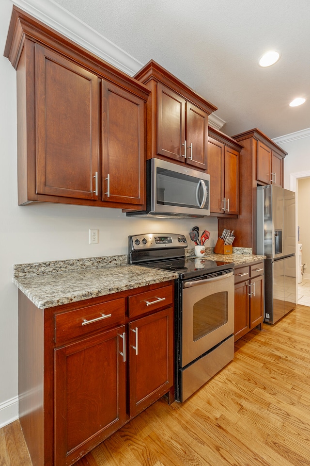 kitchen featuring ornamental molding, appliances with stainless steel finishes, light hardwood / wood-style flooring, and light stone countertops